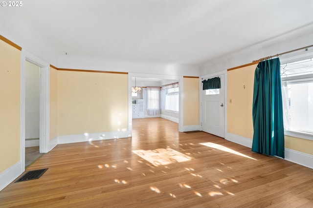 interior space with light hardwood / wood-style floors and a notable chandelier