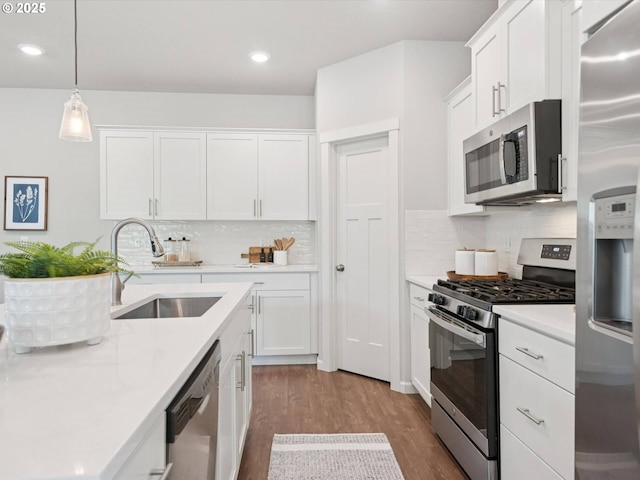 11179 SE Honorable Way, Happy Valley, OR 97086 - kitchen featuring appliances with stainless steel finishes, wood finished floors, light countertops, white cabinetry, and tasteful backsplash