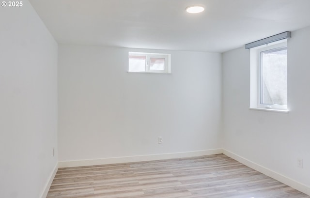 below grade area featuring light wood-style floors and baseboards