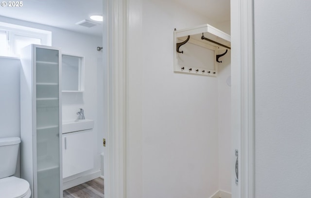 full bathroom featuring a sink, toilet, wood finished floors, and visible vents