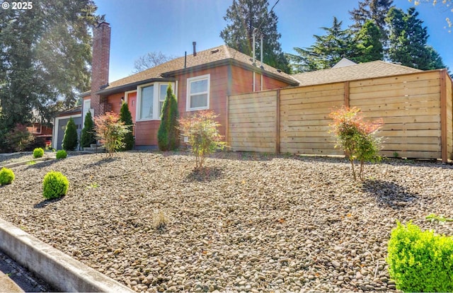 view of front of home featuring fence and a chimney