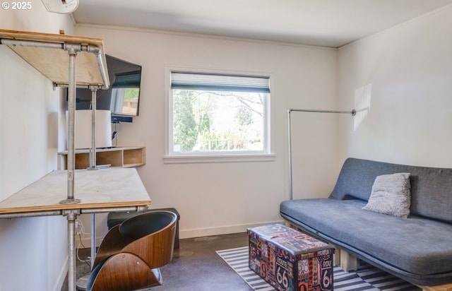 sitting room featuring baseboards and finished concrete flooring