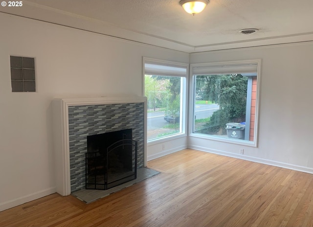 unfurnished living room featuring baseboards, visible vents, and wood finished floors