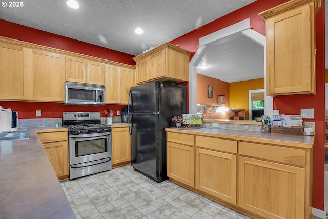 1259 SE Stapleton Loop, Gresham, OR 97080 - kitchen with appliances with stainless steel finishes, light brown cabinetry, recessed lighting, a textured ceiling, and light countertops