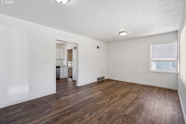 1059 16th Ave SW, Albany, OR 97321 - unfurnished room with dark wood-style flooring, a textured ceiling, and baseboards