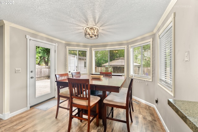 7100 SW 164th Ter, Beaverton, OR 97007 - dining room featuring light wood-style flooring, healthy amount of natural light, a textured ceiling, crown molding, and baseboards