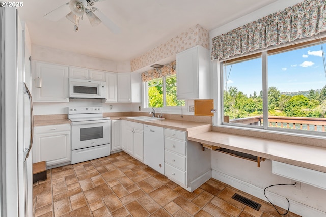 154 W Hickory St, Roseburg, OR 97471 - kitchen featuring white appliances, white cabinets, a ceiling fan, light countertops, and light stone finish flooring