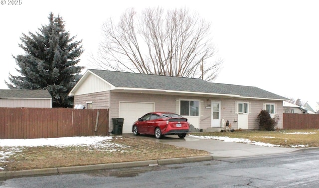 ranch-style house with a garage, fence, and driveway