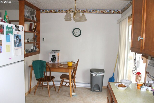 dining space with an inviting chandelier, a baseboard radiator, and a textured ceiling