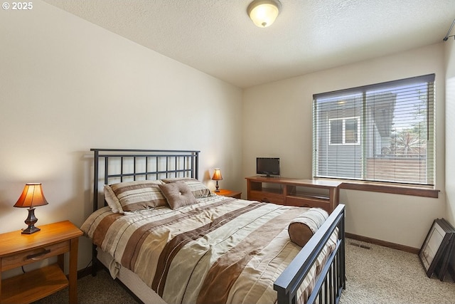 carpeted bedroom featuring baseboards and a textured ceiling
