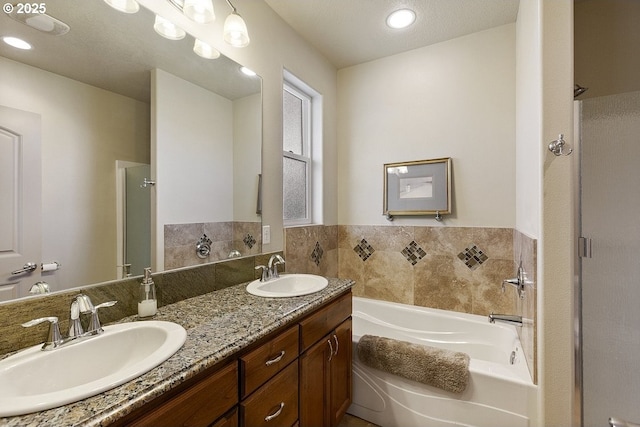bathroom featuring a stall shower, a garden tub, double vanity, and recessed lighting