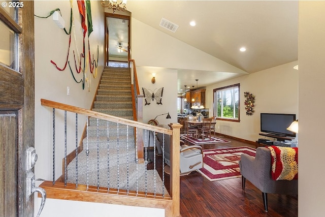 stairway with wood finished floors, vaulted ceiling, recessed lighting, and baseboards