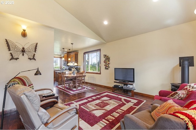 living room featuring lofted ceiling, wood finished floors, baseboards, and recessed lighting