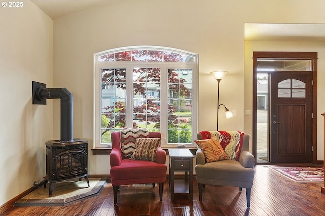living area featuring wood-type flooring and a wood stove