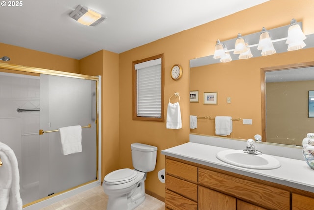 bathroom featuring vanity, a shower with shower door, and toilet