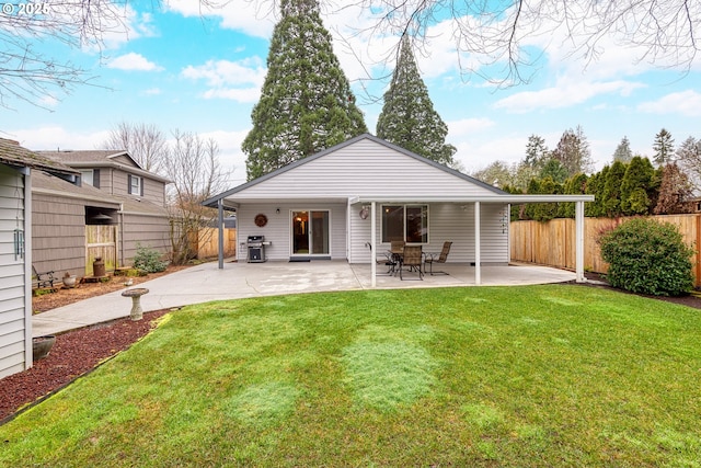 back of house featuring a patio area and a lawn