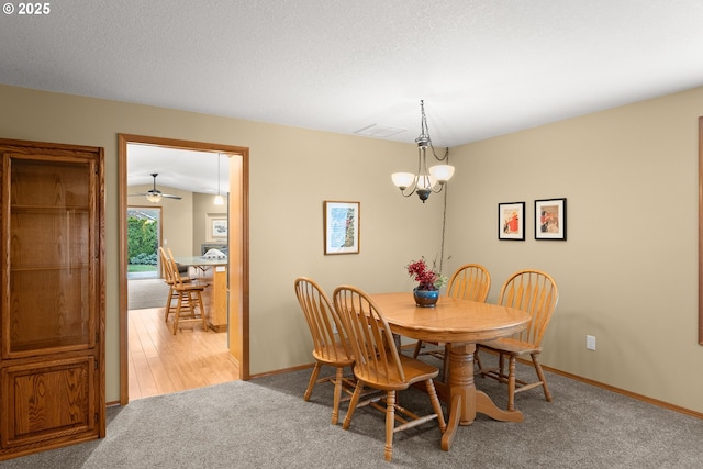 carpeted dining space with a chandelier