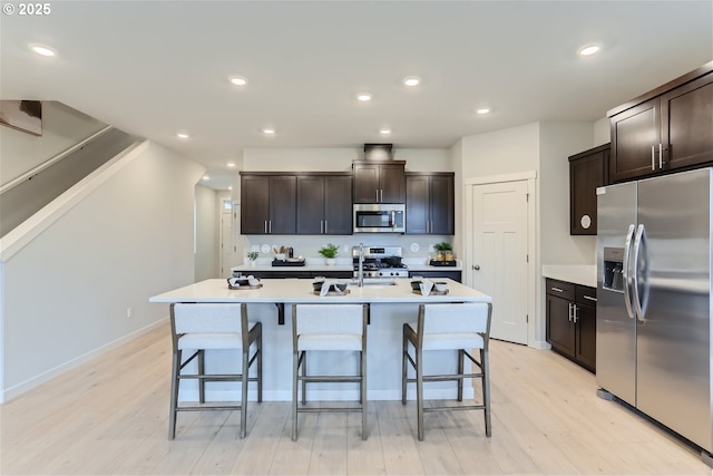 5990 Henshaw St SE, Albany, OR 97322 - kitchen featuring appliances with stainless steel finishes, light wood-type flooring, a kitchen breakfast bar, light countertops, and recessed lighting