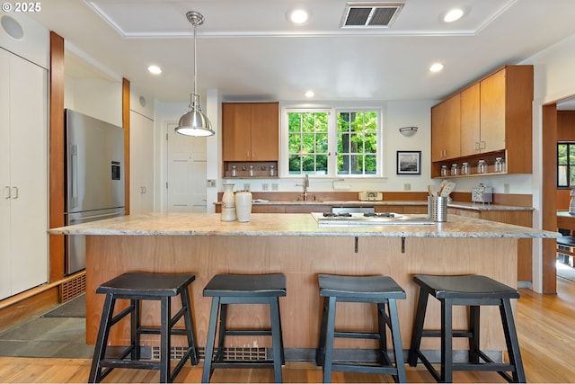 2687 NW Cornell Rd, Portland, OR 97210 - kitchen featuring stainless steel refrigerator with ice dispenser, cooktop, light stone countertops, recessed lighting, and hanging light fixtures