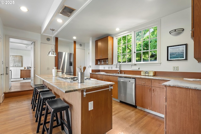 2687 NW Cornell Rd, Portland, OR 97210 - kitchen featuring stainless steel appliances, a center island, light wood-style flooring, a breakfast bar area, and recessed lighting