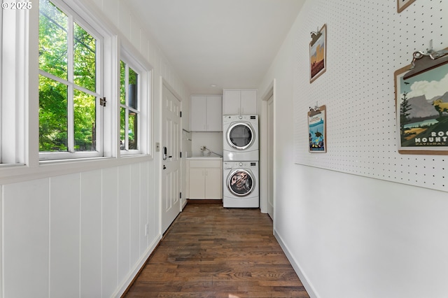2687 NW Cornell Rd, Portland, OR 97210 - washroom featuring cabinet space, estacked washer and dryer, plenty of natural light, and dark wood finished floors