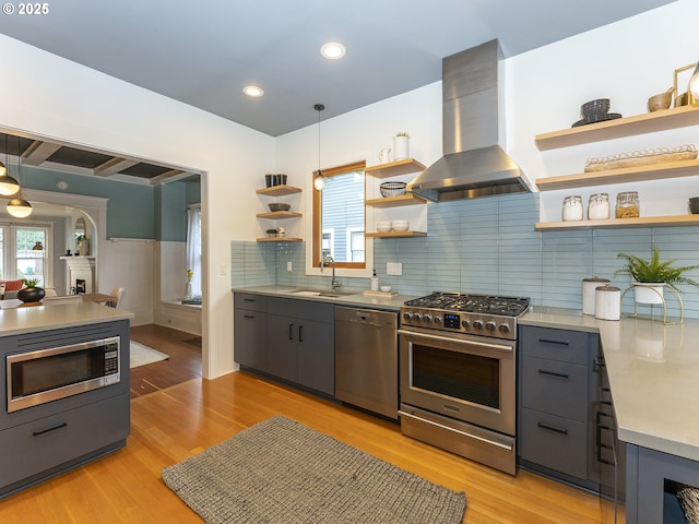 kitchen with island range hood, hanging light fixtures, stainless steel appliances, light countertops, and open shelves