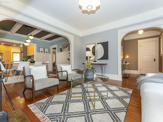 living area featuring dark wood-style floors, arched walkways, and baseboards