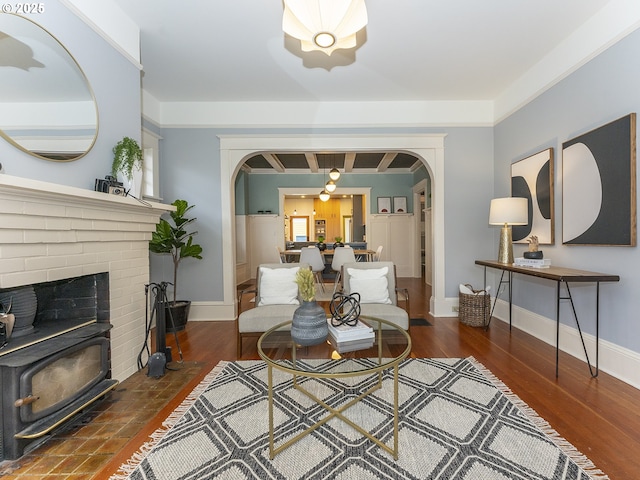 living area with baseboards, arched walkways, and dark wood-style flooring