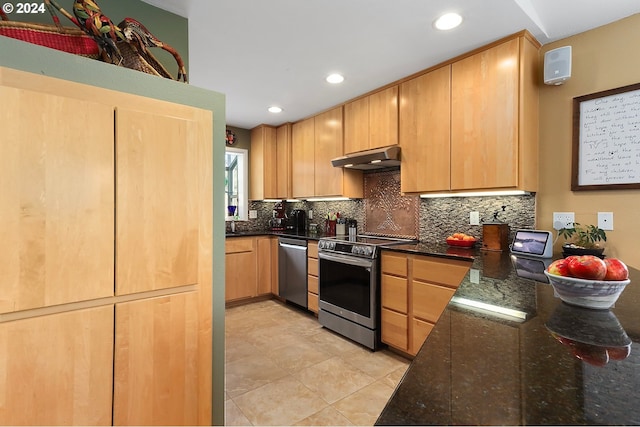 kitchen with under cabinet range hood, appliances with stainless steel finishes, decorative backsplash, and dark stone counters