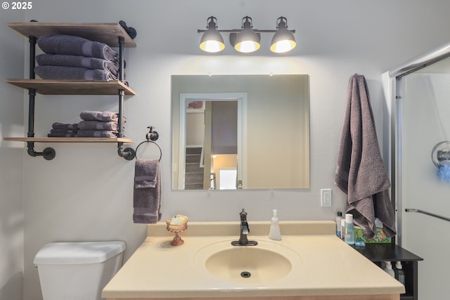 full bathroom with toilet, vanity, and a shower with shower door