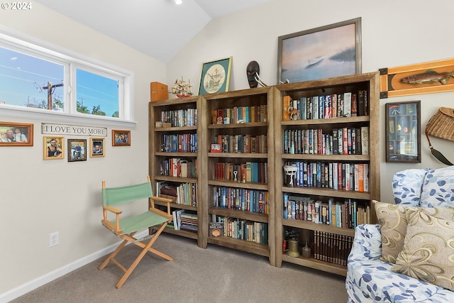 living area with carpet flooring, vaulted ceiling, and baseboards