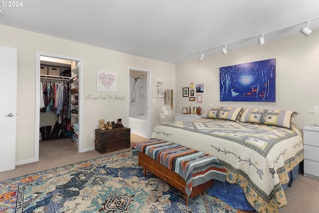 bedroom with carpet floors, a closet, a walk in closet, and rail lighting