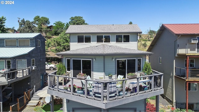 rear view of property with roof with shingles
