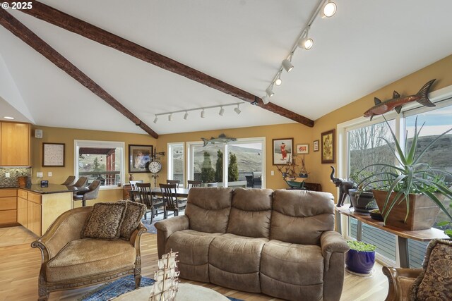 living room with lofted ceiling with beams and light wood-style floors