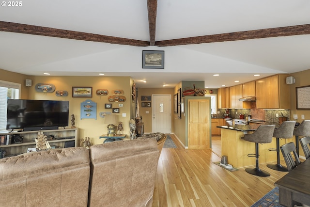 living area featuring vaulted ceiling with beams, light wood-style floors, and recessed lighting