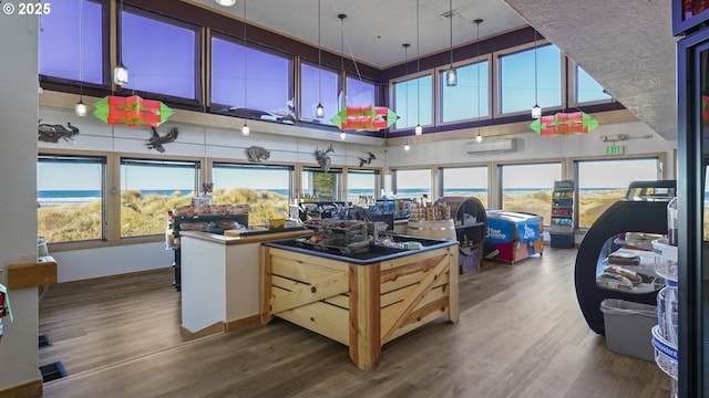 kitchen with dark wood-type flooring, a wall mounted air conditioner, and a towering ceiling