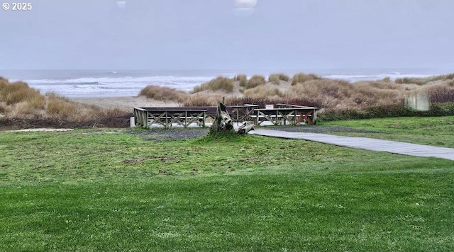 view of home's community with a water view and a yard