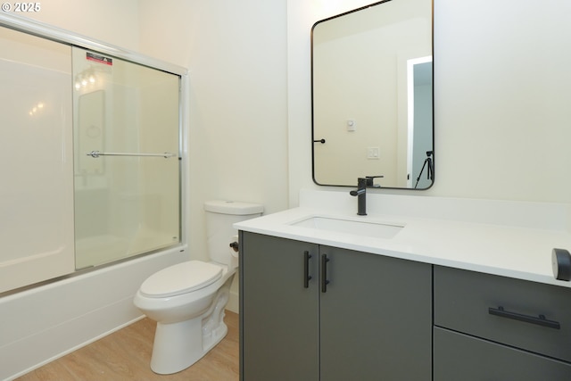 2389 SE 135th Ave Unit 11, Portland, OR 97233 - full bathroom featuring toilet, vanity, wood finished floors, and shower / bath combination with glass door