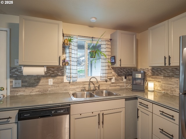 kitchen featuring stainless steel appliances, white cabinetry, sink, and decorative backsplash