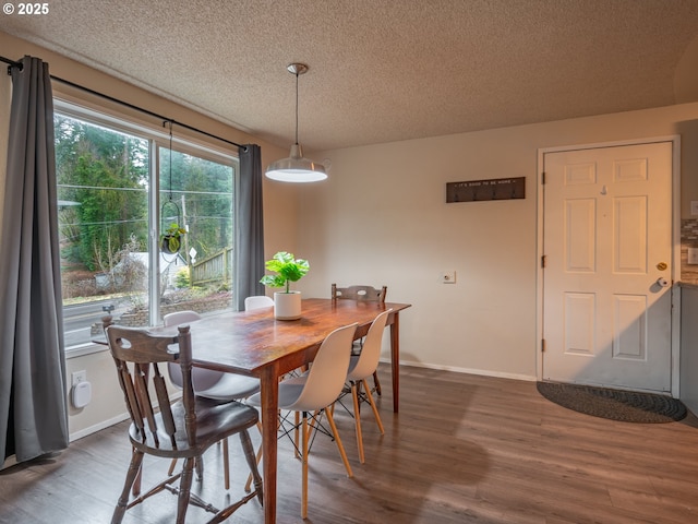 dining area featuring a textured ceiling and dark hardwood / wood-style flooring