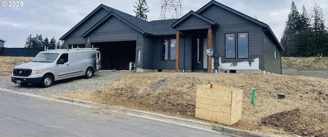 view of front of property with driveway, an attached garage, and fence