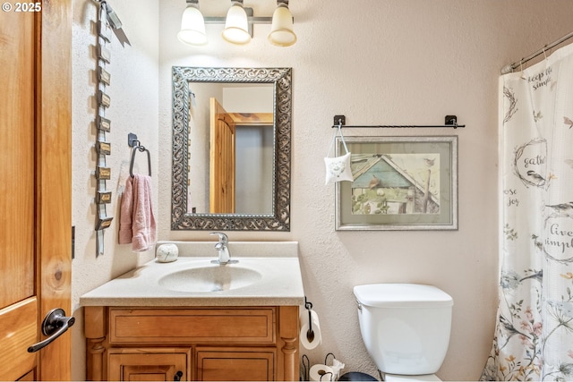 bathroom featuring a shower with curtain, vanity, and toilet