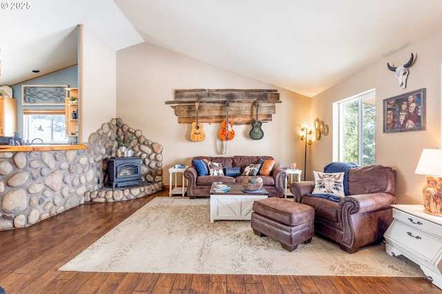 living room with hardwood / wood-style floors, vaulted ceiling, and a wood stove