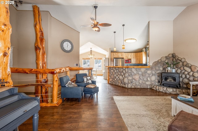 living room featuring lofted ceiling, dark wood-type flooring, a wood stove, and ceiling fan