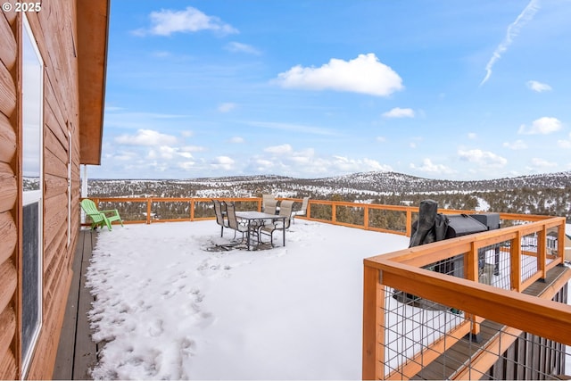 snow covered deck with a mountain view