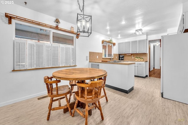 61241 Perry Creek Rd, Saint Helens, OR 97051 - dining area with a notable chandelier, light wood-style floors, visible vents, and baseboards