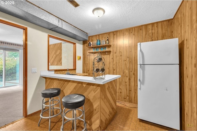 61241 Perry Creek Rd, Saint Helens, OR 97051 - bar featuring wood walls, wet bar, freestanding refrigerator, tile patterned floors, and a textured ceiling