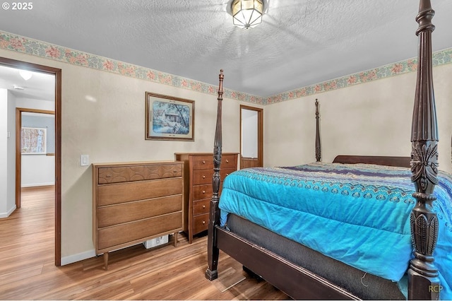 61241 Perry Creek Rd, Saint Helens, OR 97051 - bedroom featuring a textured ceiling, baseboards, and wood finished floors