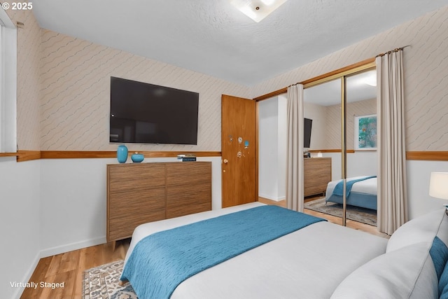 61241 Perry Creek Rd, Saint Helens, OR 97051 - bedroom featuring baseboards, wood finished floors, a closet, and a textured ceiling