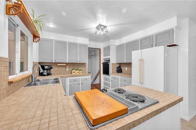 61241 Perry Creek Rd, Saint Helens, OR 97051 - kitchen featuring gray cabinetry, a sink, tasteful backsplash, appliances with stainless steel finishes, and light countertops